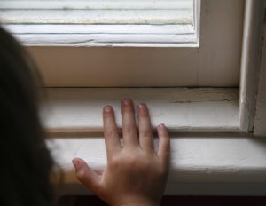 Picture of a child's hand on an old window frame